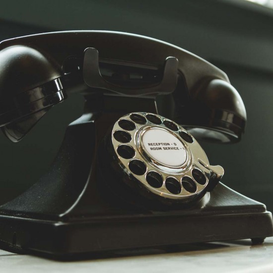 Black Rotary Telephone on White Surface