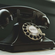 Black Rotary Telephone on White Surface